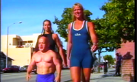 The video begins with Rose 5'11" and her friend Susan 6'0" walking down the street flanking a muscular man who can't be any more than 4'6", if that. In their swimsuits, these towering muscular and leggy Amazons dwarf this little guy (no pun intended). The last time I saw a sight like that it was of a tugboat between two enormous ocean liners. Even though it looks like these two women could end the man's existence by simply coming together to hug each other, the little fellow appeared happy to be walking between them. In fact, he even got admiring comments from gawking passersby who marveled at his company. One man on the street was overheard to say, "He's got all the luck and a bag of chips!" Following along behind these three we are stunned to see the man's little muscular shoulders at the same height above street-level as these two Amazons' fantastic and curvaceous rears. We watch as the women walk along, each holding the little man by the hand as though he were a. In their high heels, these women each push 6'4". What an experience this must have been for him! There are also some fine shots following the feet of these big girls as they walk firmly along in their high-heeled sandals.